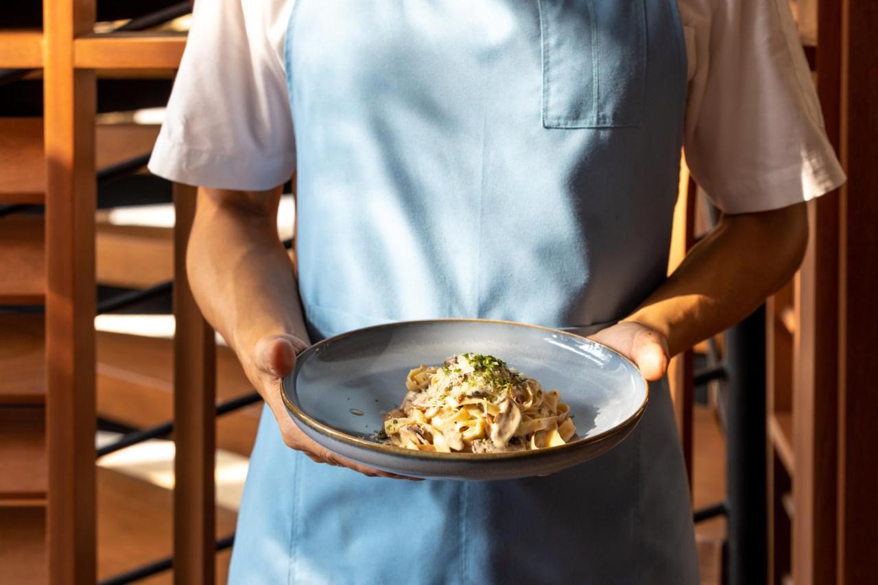 Outrigger Surin Beach Resort - Sha Extra Plus Eksteriør billede A server holding a plate of pasta